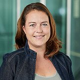 STRAGAB Ausbildungskoordinatorin KV schaut lächelnd in die Kamera. Im Hintergrund ist ein Lift zusehen.