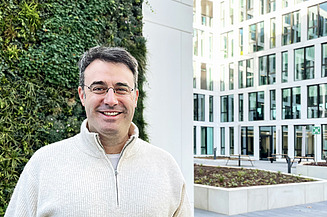 Männlicher Mitarbeiter steht vor dem Innovation Center Neubau in Stuttgart