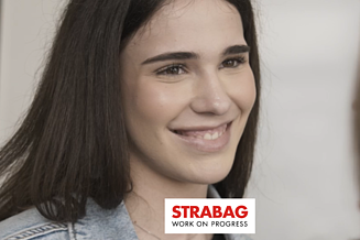 Junge KV-Lernende mit dunklen Haaren und einem strahlendem Lächeln gegenüber einer anderen Person